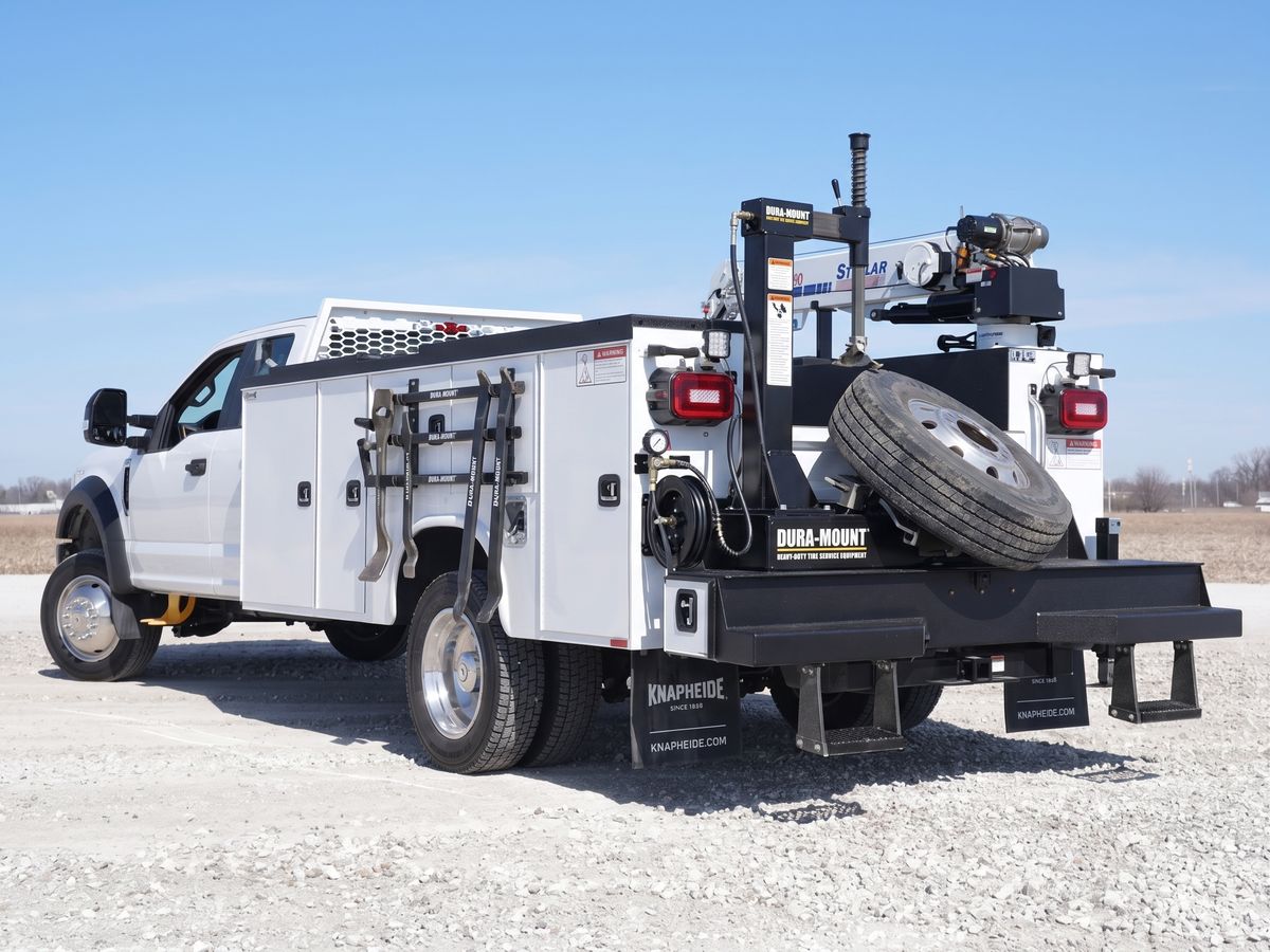 Mobile diesel service truck with a crane, tire changing equipment, and tool compartments